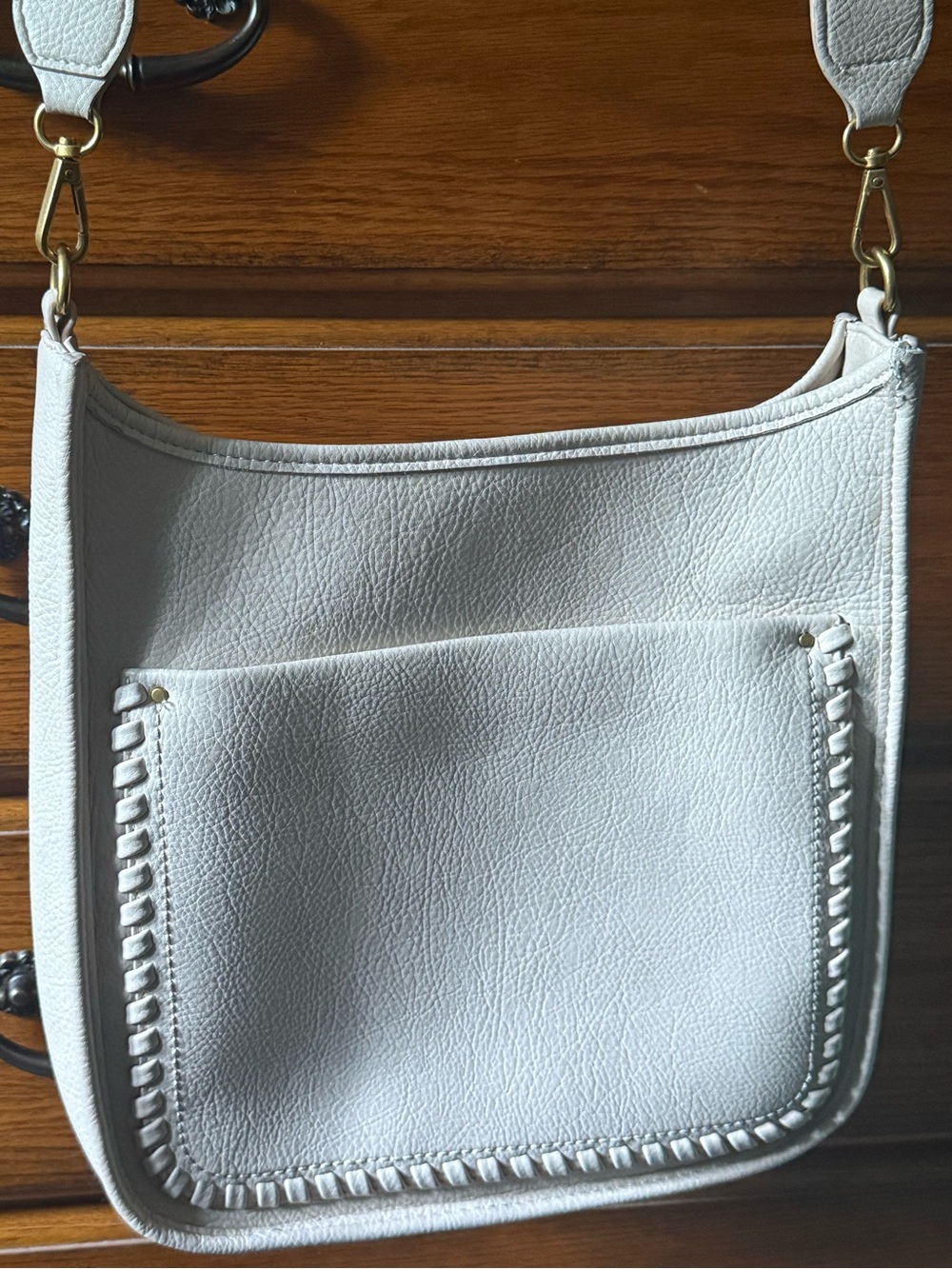 Cream faux Leather Crossbody Bag with Whipstitch Front Pocket and back pocket.